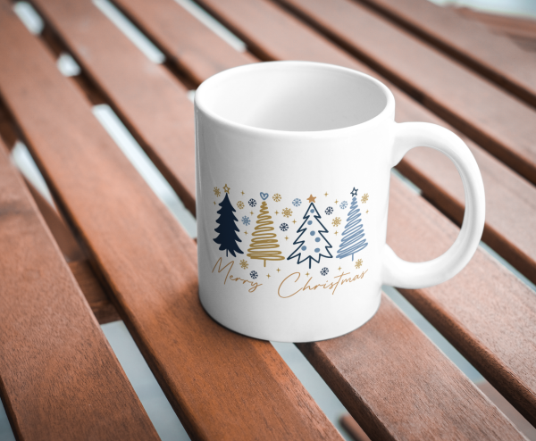 Weiße Merry-Christmas-Tasse mit modernem Weihnachtsbaum-Design auf Holztisch.