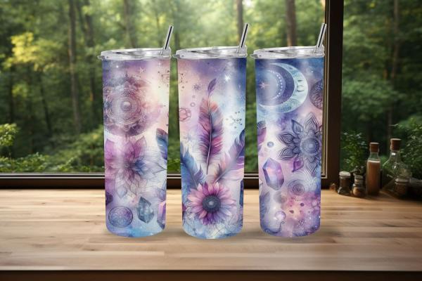 Drei Thermobecher mit mystischem Design, das Mandalas, Federn, Kristalle und Mondphasen in zarten Blau- und Lilatönen zeigt. Die Becher stehen auf einer Holzoberfläche mit einem Wald im Hintergrund und verleihen dem Bild eine ruhige und spirituelle Atmosp