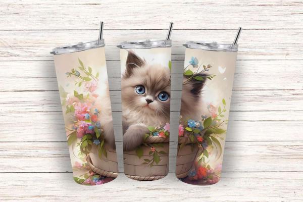 Drei Thermobecher mit einem niedlichen Design, das ein flauschiges Kätzchen in einem Korb zeigt, umgeben von bunten Blumen und Blättern. Der Hintergrund ist in sanften, warmen Farben gehalten und vermittelt eine fröhliche, naturverbundene Atmosphäre, idea