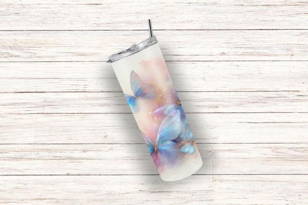 Ein eleganter Thermobecher auf einer weißen Holzoberfläche, verziert mit einem Design aus pastellfarbenen Schmetterlingen. Die Schmetterlinge in zarten Blau- und Rosatönen vermitteln eine luftige, verträumte Atmosphäre und heben sich sanft vom Becher ab.