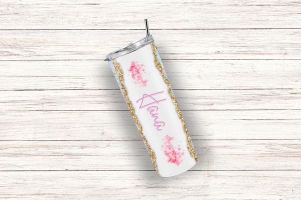 Ein einzelner Thermobecher mit personalisiertem Design, der den Namen 'Hana' in pinker Schrift zeigt. Der Becher hat einen weißen Hintergrund mit zarten rosa Blumenmotiven und goldenen Glitzer-Details an den Rändern. Der silberne Deckel und der Edelstahls