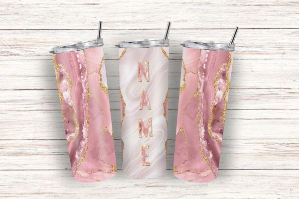 Drei Thermobecher mit elegantem rosa und cremefarbenem Marmor-Design, verziert mit goldenen Glitzerakzenten, auf einem hellen Holz-Hintergrund. Der mittlere Becher hat den Schriftzug 'NAME' in großen roségoldenen Buchstaben. Die Becher sind mit silbernen