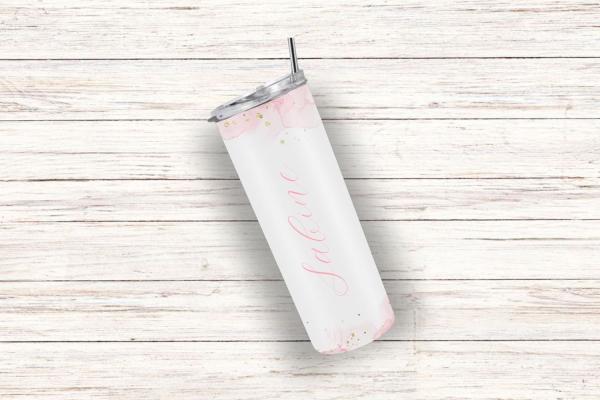 Ein personalisierter Thermobecher mit dem Namen „Sabine“, gestaltet in einem zarten rosa Aquarell-Design mit goldenen Akzenten. Der Becher liegt leicht schräg auf einem hellen Holzuntergrund.