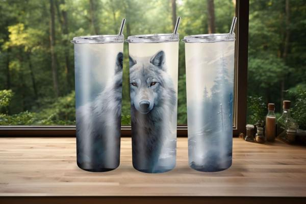 Drei Thermobecher mit stimmungsvollem Wolfsmotiv, das einen majestätischen grauen Wolf in einer nebeligen Waldlandschaft zeigt. Der mittlere Becher hebt das Gesicht des Wolfs hervor, während die äußeren Becher eine ruhige Waldszene mit Nebel und Bäumen da