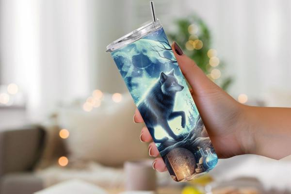 Thermobecher mit zauberhaftem Wolfsmotiv. Ein Wolf, beleuchtet vom Mondschein, wandert durch eine mystische Landschaft mit magischen Symbolen, Flaschen und Kerzen auf einem Hintergrund aus blauen und lila Farbtönen. Perfekt für Naturliebhaber und Fans von
