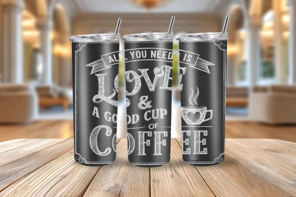 Schwarzer Thermobecher mit großem, weißem Kreideschriftzug 'All you need is love & a good cup of coffee', dekoriert im Retro-Tafelstil.