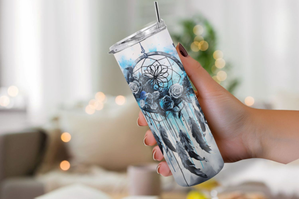 Hand hält einen Thermobecher mit mystischem Traumfänger-Design in Schwarz-, Grau- und Blautönen, verziert mit Rosen und Federn. Das Motiv vermittelt eine geheimnisvolle und künstlerische Atmosphäre, perfekt für Liebhaber des Boho-Stils.
