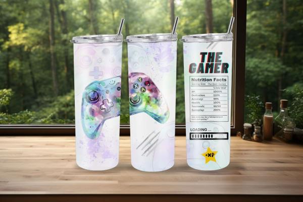 Drei Thermobecher mit verspieltem Gaming-Design: Ein bunter Controller in Aquarelloptik und ein humorvolles 'The Gamer'-Label mit 'Nährwertangaben' wie XP, Engagement und Genauigkeit. Perfekt für Gaming-Fans, die ein kreatives und witziges Design suchen.
