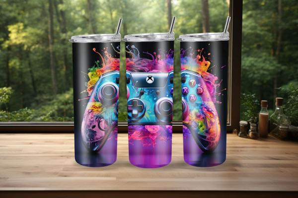Drei Thermobecher mit farbenfrohem Gaming-Controller-Design, umgeben von explosiven, lebendigen Farbspritzern auf schwarzem Hintergrund. Perfekt für Gaming-Enthusiasten, die ein auffälliges und dynamisches Design suchen.