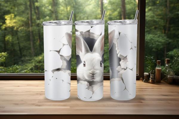 Thermobecher-Design mit einem niedlichen weißen Kaninchen, das aus einem realistischen Riss in der Becheroberfläche hervorlugt. Der Hintergrund ist in einem hellen Weißton gehalten, der das Kaninchen und die gebrochenen Wandeffekte um den Riss herum hervo