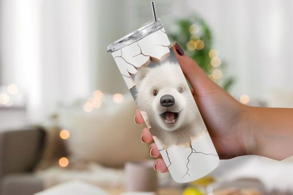 Thermobecher in der Hand gehalten mit einem fröhlichen Eisbären-Design. Der Bär schaut aus einem realistisch gestalteten Riss in der Becheroberfläche heraus, was den Eindruck erweckt, als ob der Bär direkt durch die Oberfläche bricht. Der Hintergrund ist