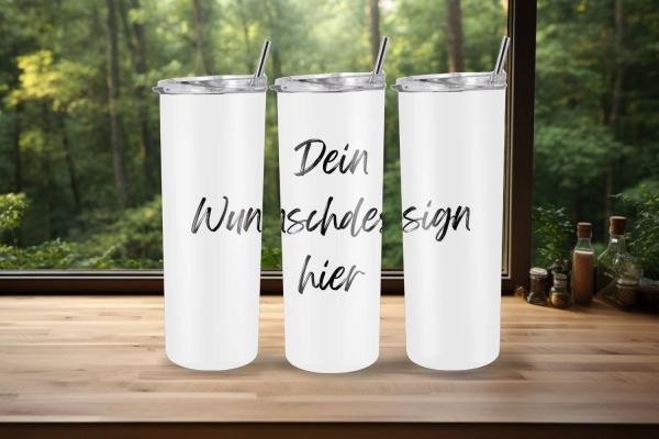 Drei weiße Thermobecher auf einer Holzfläche vor einem Fenster mit grüner Waldlandschaft im Hintergrund. Auf den Bechern steht in schwarzer Schrift: 'Dein Wunschdesign hier', was Platz für eine individuelle Gestaltung bietet.