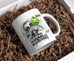 Weiße Halloween-Tasse mit niedlichem, gruseligem Skelettkind und grünem Kürbis-Luftballon, umgeben von Fledermäusen und farbigen Sprenkeln. Der Schriftzug 'Happy Halloween' verleiht der Tasse einen festlichen Touch.